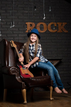 Little girl in hat with guitar