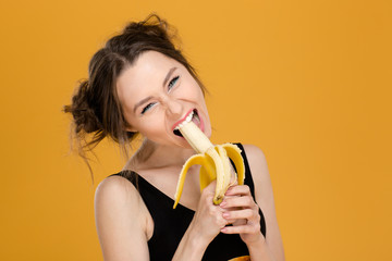 Portrait of funny beautiful young woman eating banana