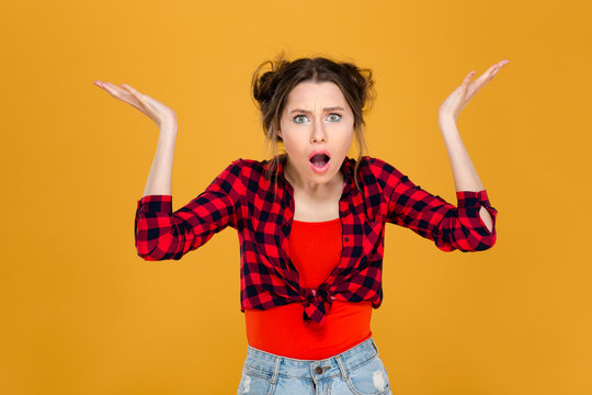 Shocked confused woman with raised hands holding copyspace on palms