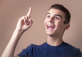 Attractive young man have an idea, pointing up his finger, horizontal background