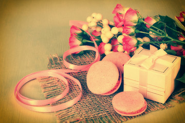 a bouquet of roses with ribbon and sweets near the gift boxes on cloth on a wooden green table,photo in the filter