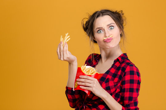 Funny pretty young woman making fake moustache with fries