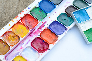 Palette of used watercolors with vibrant and mixed hues