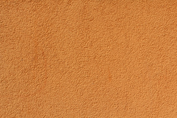 Orange stucco relief on the wall of the house. Backgrounds and t