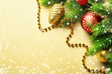 Christmas fir tree branches with toys and beads on paper background