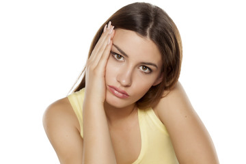 Fototapeta premium nieszczęśliwa i znudzona młoda kobieta na białym tle