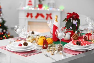 Christmas table setting with holiday decorations on fireplace background