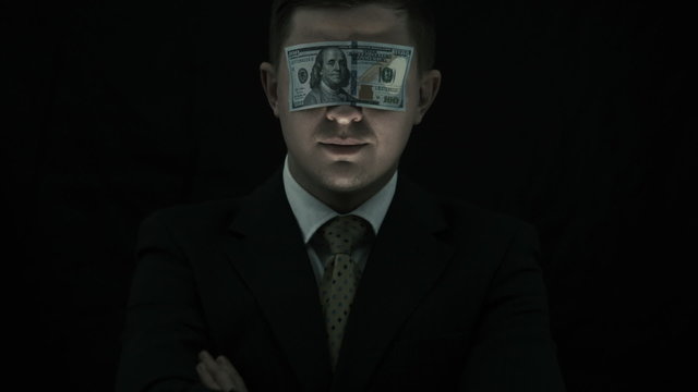 Corruption, person with scary face closed his mouth by the money