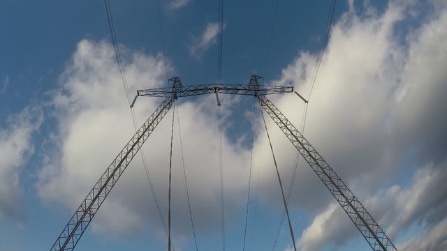 Electric high voltage pylon against sky. Time lapse.