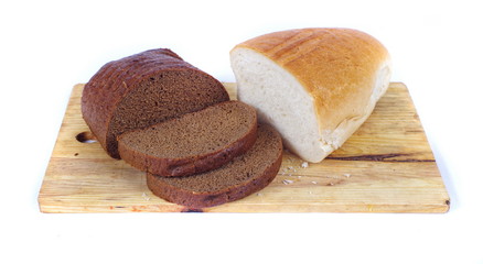 rye and white loafs of bread on chopping board closeup isolated