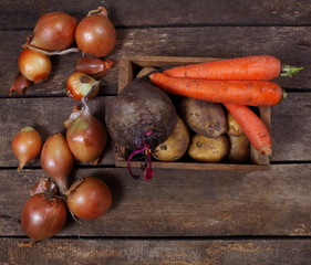 farm vegetables are scattered on a wooden table closeup top view