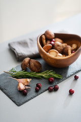 Closeup of autumn fruits and mushrooms in a wooden bowl