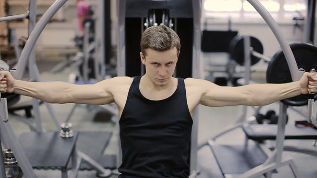 Man in gym on machine exercising slow motion