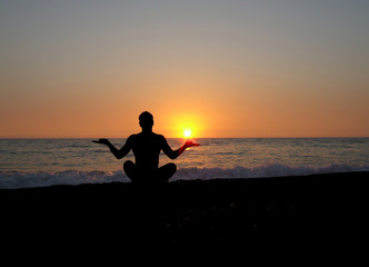 A man in a lotus position doing yoga on the backdrop of the sett