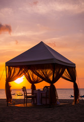 Romantic dinner setting on the beach at sunset