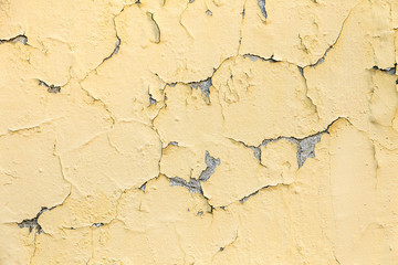 peeling yellow and white paint on a rough surface