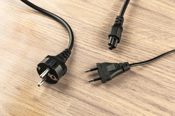 Еlectrical plugs on a background of wooden floor