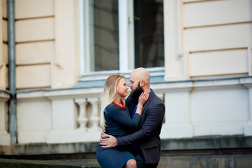 Fototapeta premium One beautiful stylish emotional couple of young woman and senior man with long black beard embracing sitting close to each other