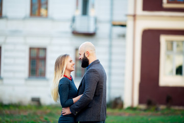 Fototapeta premium Portrait of happy couple hugging in the city and standing face to face. Beautiful people in love.