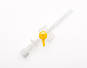 Yellow plastic catheter with needle closed by protective cap isolated on white background. Clipping path included.