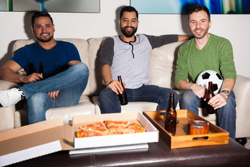 Guys watching a soccer game at home