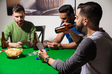 Guys drinking beer on poker night