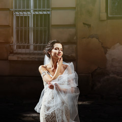 Gorgeous happy smiling brunette bride in vintage white dress pos