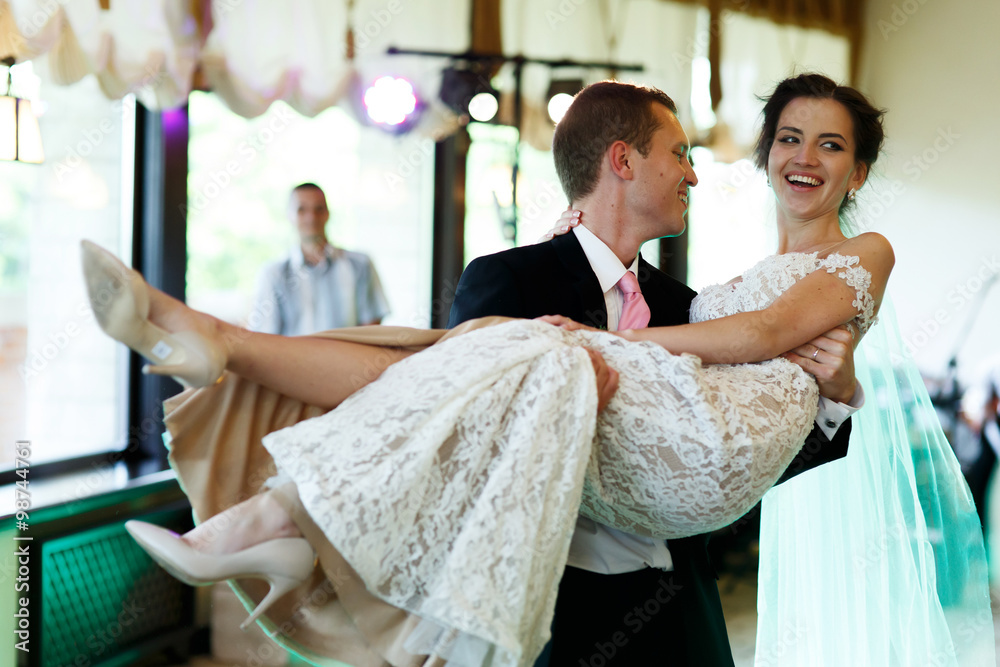 Canvas Prints Handsome strong groom holding beautiful sexual brunette bride in