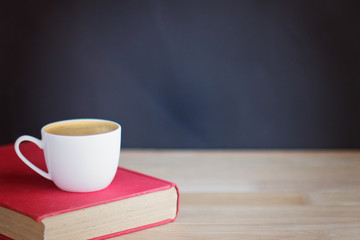Coffee cup and book over wood
