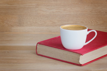 Coffee cup and book over wood