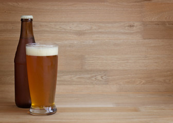 Red beer in glass and bottle over wood