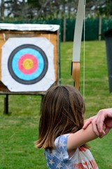 Young girl shoots bow and arrow