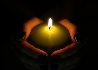 burning candle in the hands 