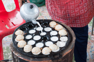 A man is cooking Kanom Krok , kind of Thai sweetmeat
