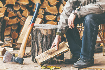 man sits in chair and crushes log