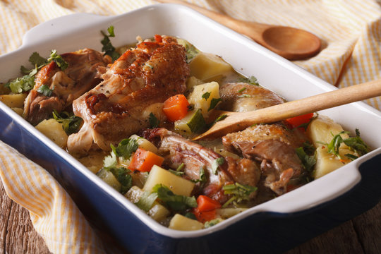 Tasty chicken stew with potatoes and carrots in a dish close-up. Horizontal
