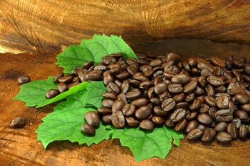 Naklejka premium Coffee beans on the wooden background.