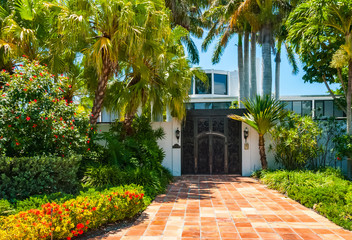 Architectural building in Florida entrance door of tropical luxury villa. Palm trees in front of beautiful mansion with terracotta floor tiles on sunny day in summer - 98761363