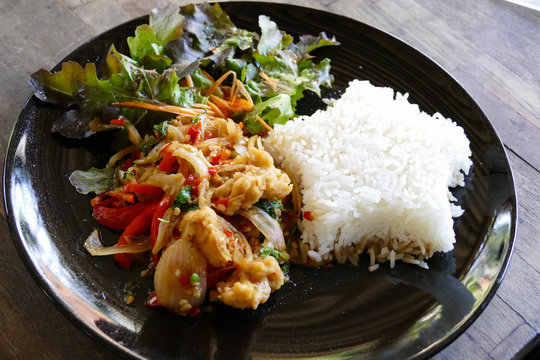 fish stir fry with chili sauce serving with rice and vegetable