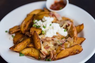 Potato wedges with bacon and white cream