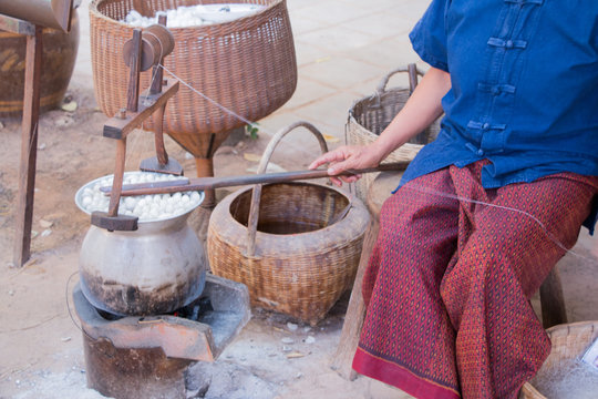 Boiling cocoon silkworm in a pot to prepare silk thread