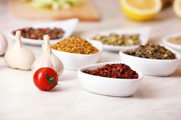 Variety of spices in ceramic containers on the kitchen table