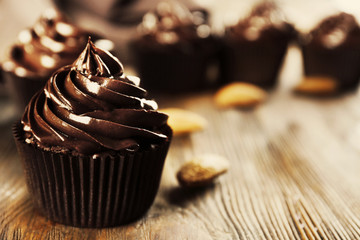 Chocolate cupcakes with nuts on wooden table