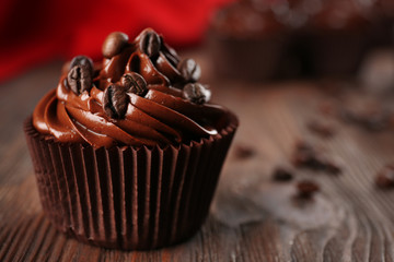 Chocolate cupcakes and coffee beans on wooden table