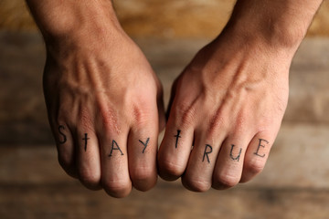 Tattoo inscriptions on male fingers drawn with marker