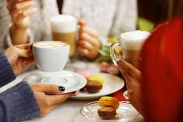 Women meeting in cafe and drinking latte