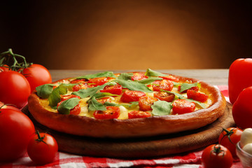 Pizza Margherita with vegetables on brown background