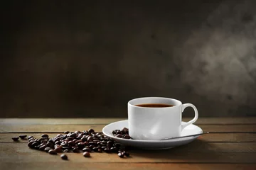 Rolgordijnen Kopje koffie en koffiebonen op houten tafel, op grijze achtergrond © Africa Studio