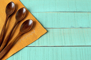   Spoons wooden. Three wooden spoons on linen napkin on wooden background.
  