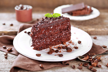 Chocolate cake with chocolate cream and fresh berries on plate, on wooden background